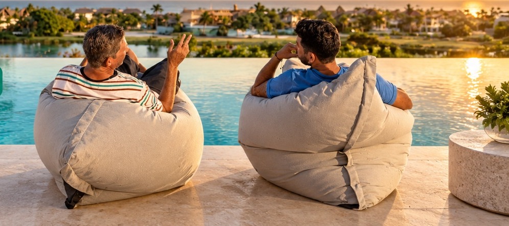 Dos personas descansando en bean bags junto a la piscina
